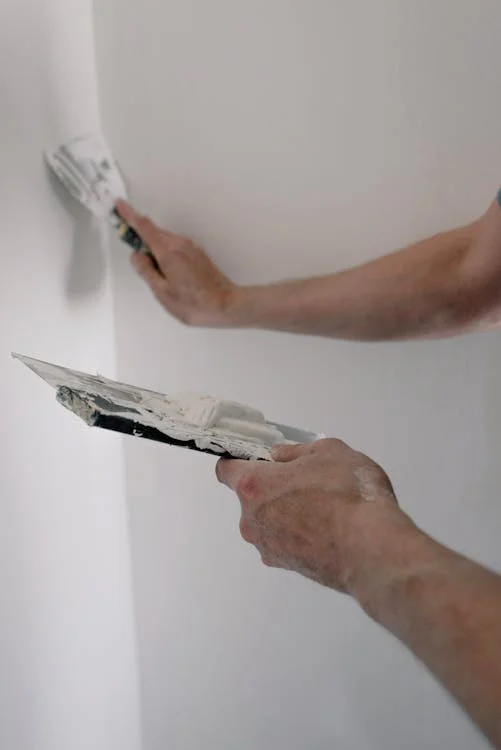Interior wall being covered with plaster cladding, adding a refined and smooth texture to the room — by Cladding Wellington.