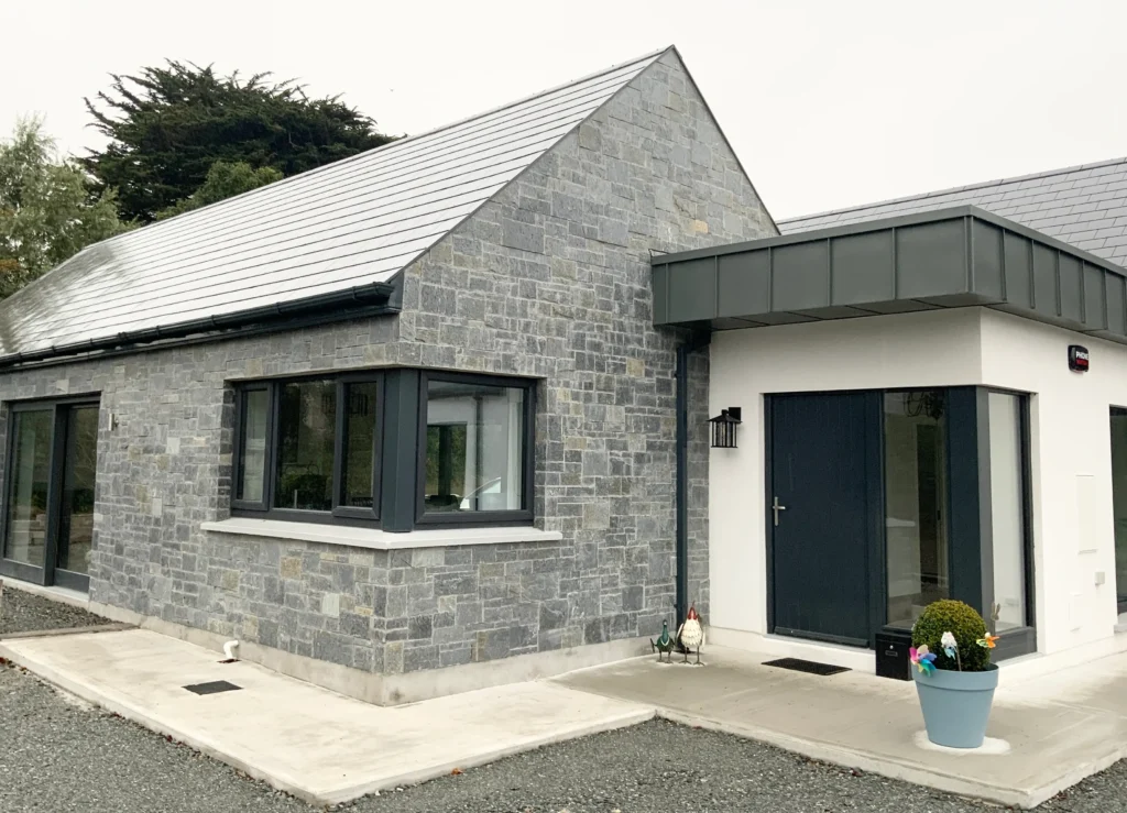 House featuring elegant stone cladding on the exterior, enhancing both aesthetics and durability — by Cladding Wellington.