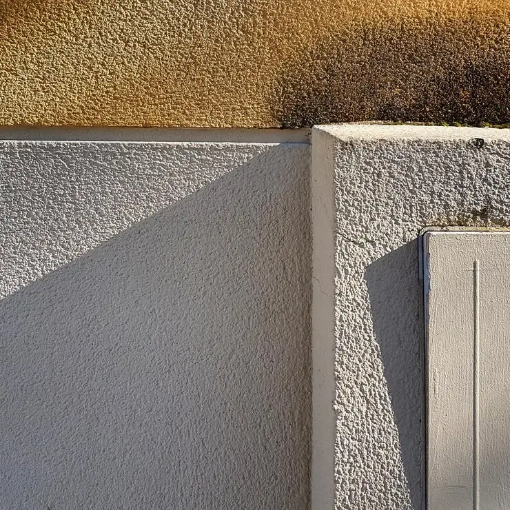 Wall featuring stucco cladding, providing a textured and durable exterior finish — by Cladding Wellington.