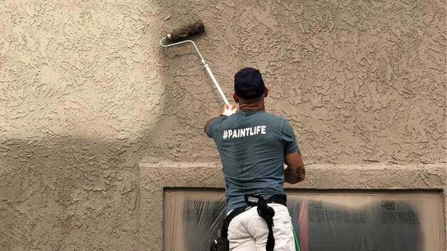 Worker applying stucco cladding to a house wall, ensuring a seamless and durable exterior — by Cladding Wellington.